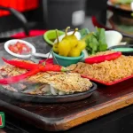 Food photography of La Cresta fajita with rice and peppers on wood.